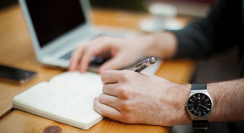 man writing with pen