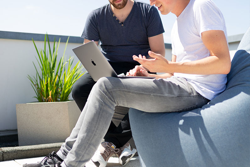 two young men talking computer