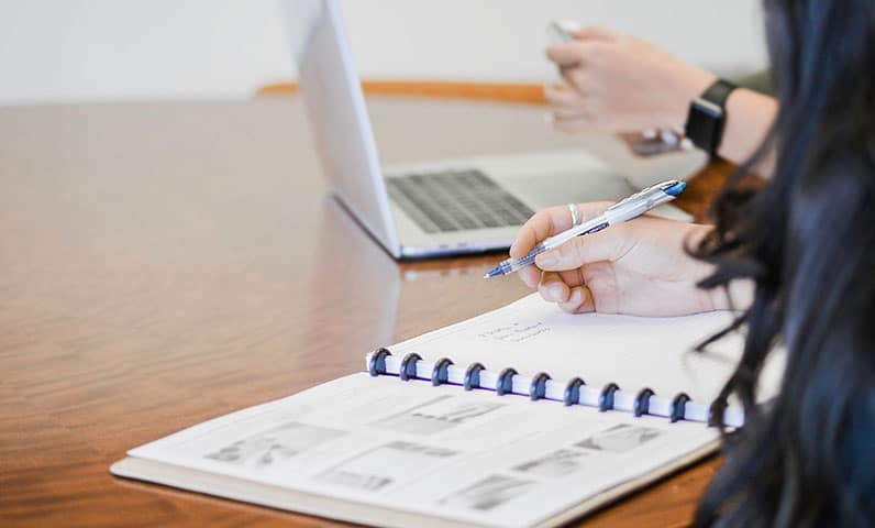 woman writing on notebook