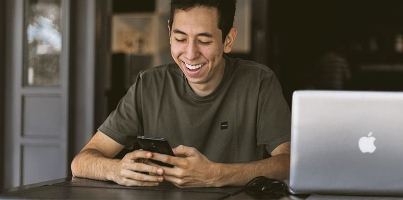 happy man smile at phone laptop