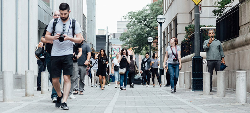 group of people using phone and walking in the street