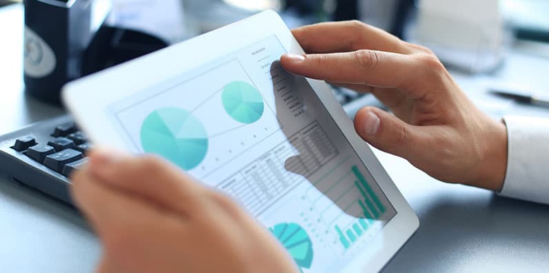 hands holding a tablet showing pie charts