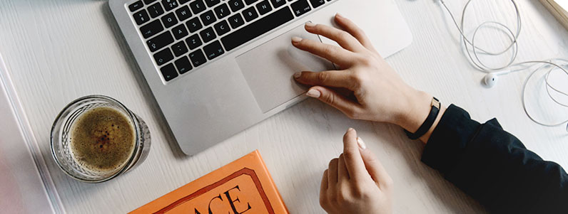 hands on a table using laptop