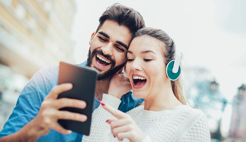 happy couple using tablet and headphones