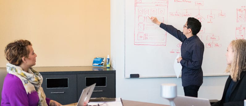 man pointing to a whiteboard