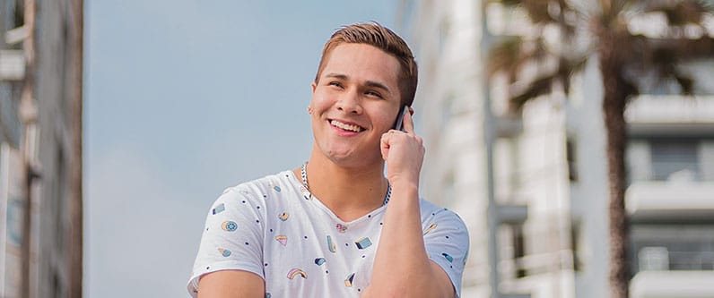 smiling young man making a phone call