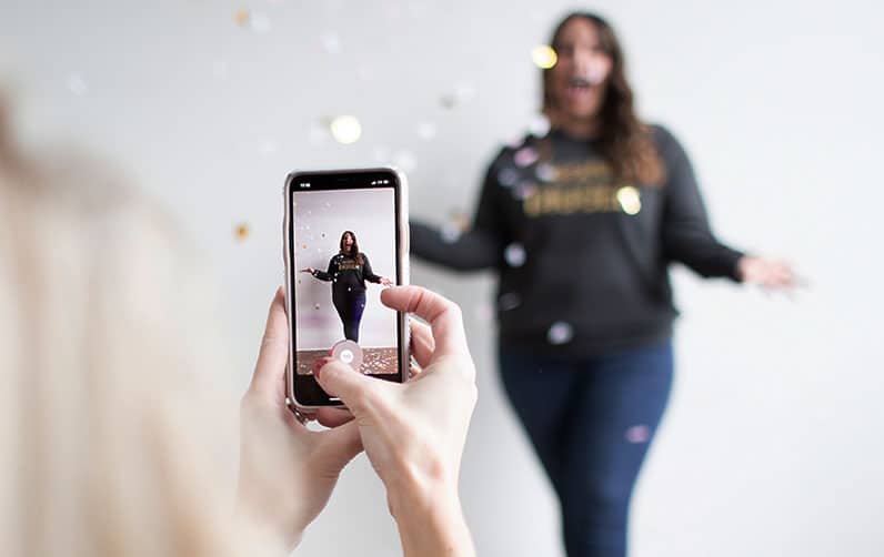 girl taking a picture of a girl with smartphone