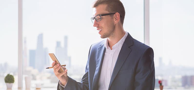 smiling man looking at phone screen