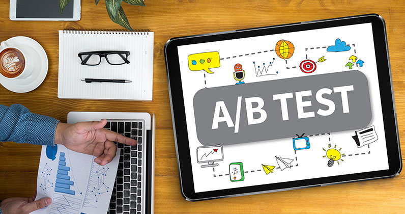 table with electronic devices big tablet showing ab test and mans hand