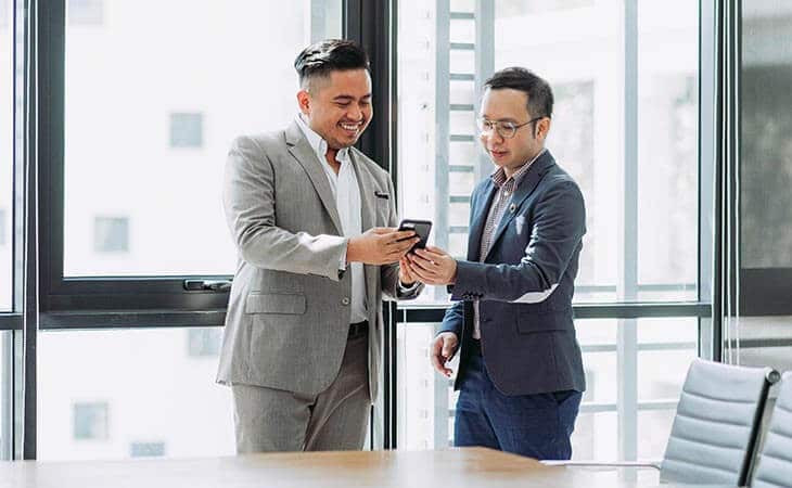 two men watching phone