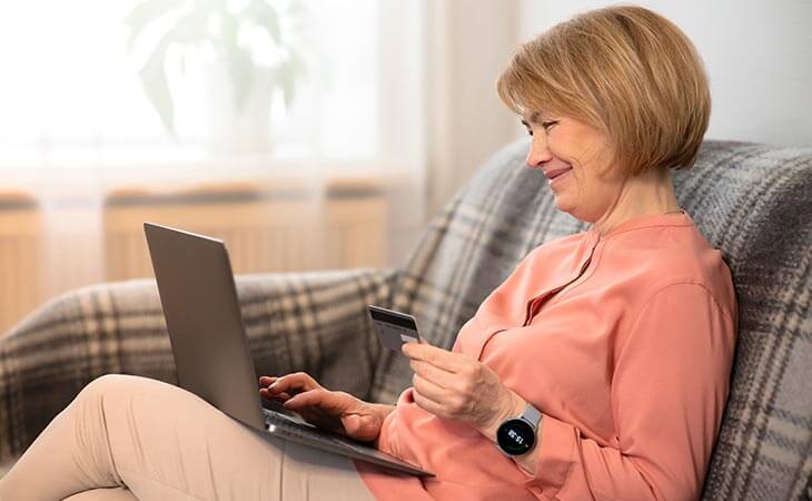 woman holding card laptop