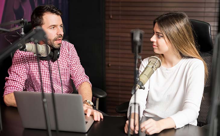 male radio broadcaster interviewing female studio