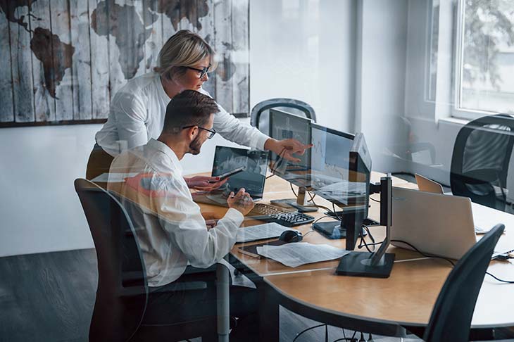 two office coworkers pointing screen