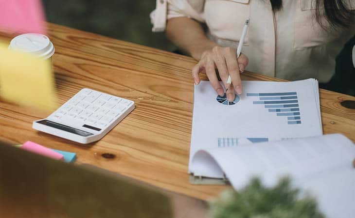 woman using calculator sheets accounting