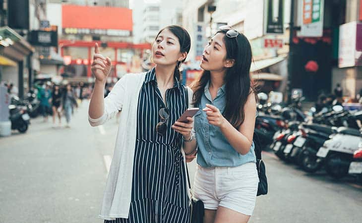 two women street pointing place