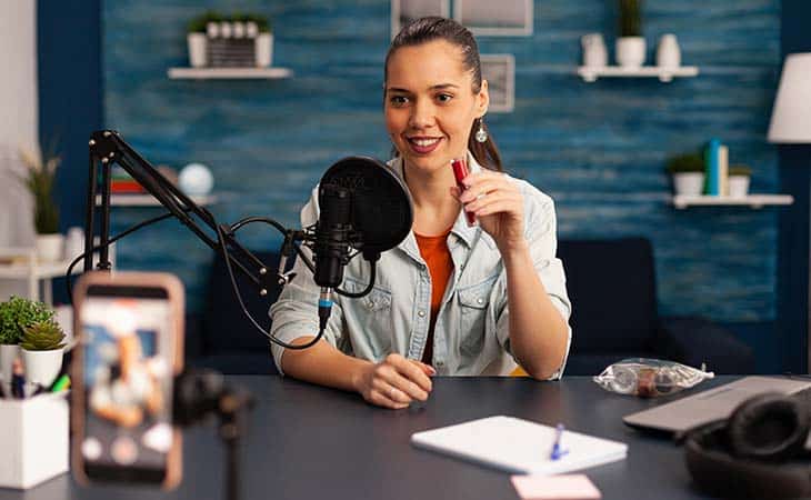 woman recording video phone mic desk