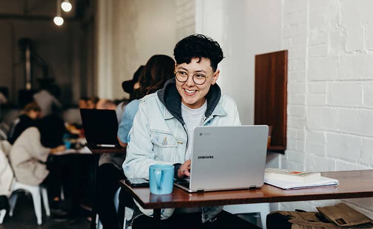 smiling woman with a laptop in a cafe