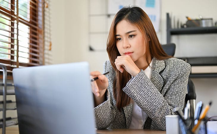 woman working and thinking with a laptop