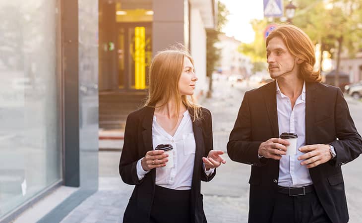 a couple in a business attire walking on the street