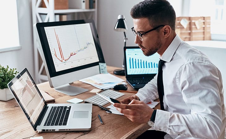 Job Descriptions For Executives (With Template &Amp; Examples) Evinex Corporation | Staffing Agency man analyzing data in several screens
