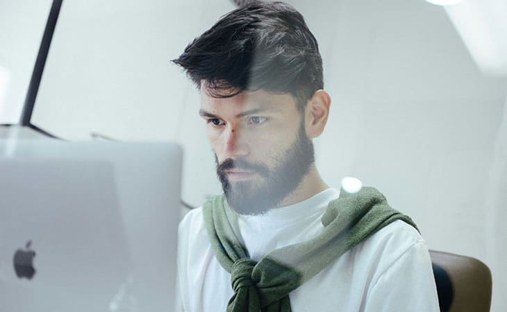 Product Manager Job Description: Guide, Template &Amp; Tips Evinex Corporation | Staffing Agency manager focusing on his job with a computer