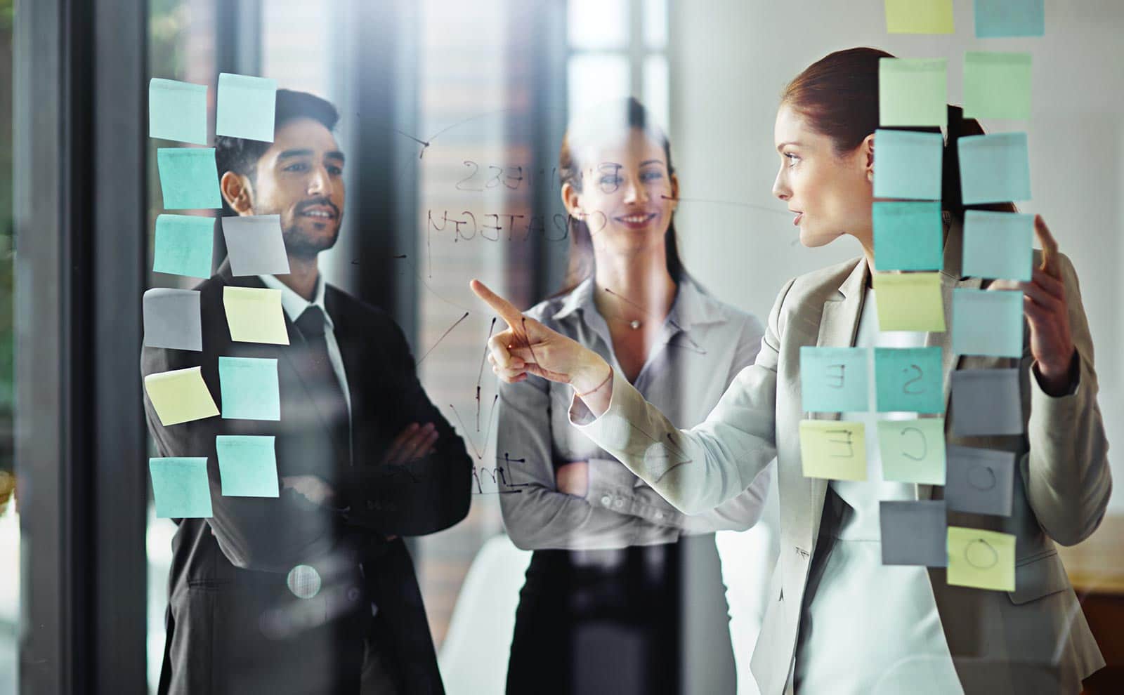 team working with post-its in a transparent wall