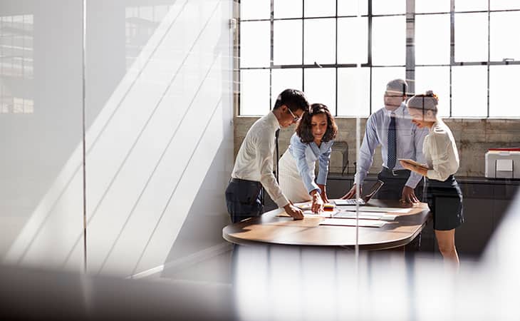 100+ Interview Questions For Executives With Sample Answers Evinex Corporation | Staffing Agency group of people working together around a table