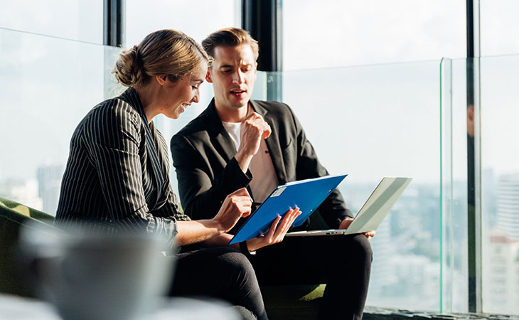 Program Manager Job Description: Essential Skills Guide Evinex Corporation | Staffing Agency man-woman-sitting-talking-working