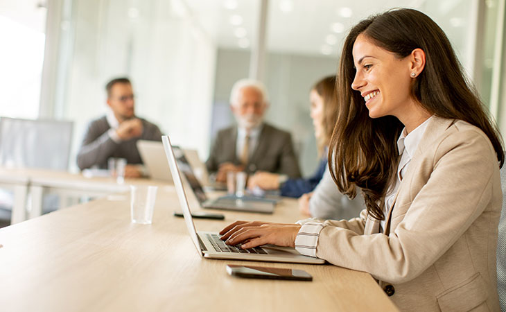 smiling-woman-working-laptop-office