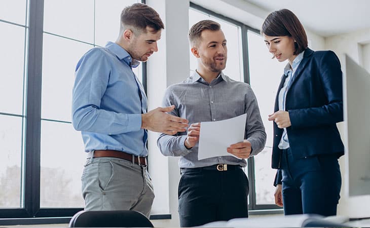 100+ Interview Questions For Executives With Sample Answers Evinex Corporation | Staffing Agency three coworkers reading a paper