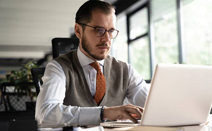 man-glasses-tie-using-laptop