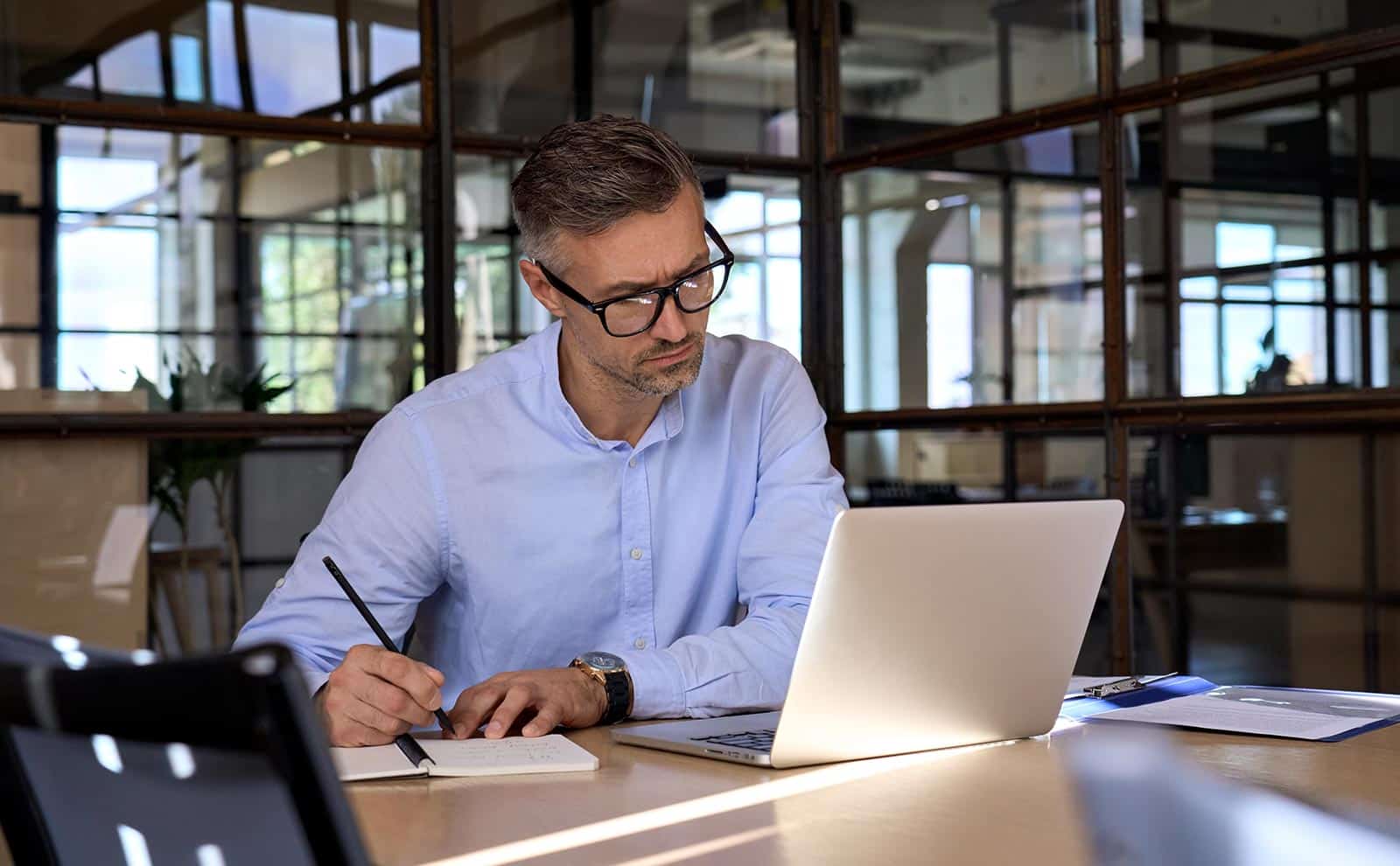 man-handwriting-using-laptop