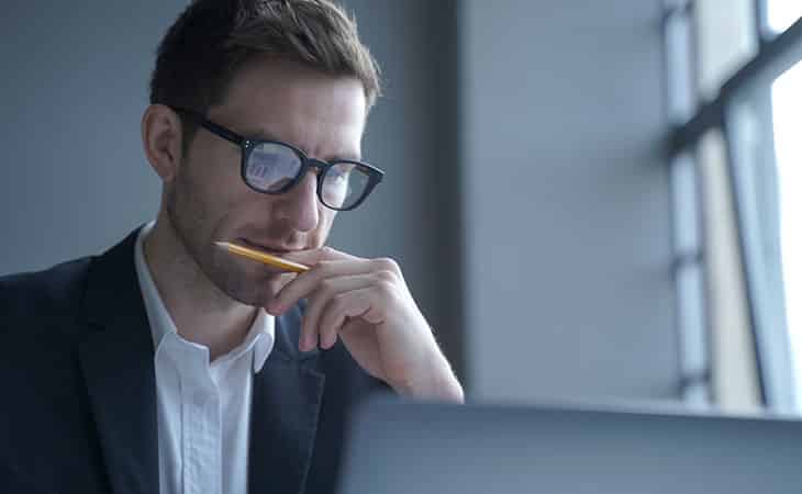 man-pencil-looking-computer