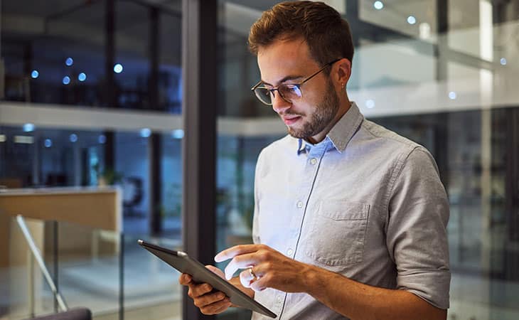 man-standing-using-tablet