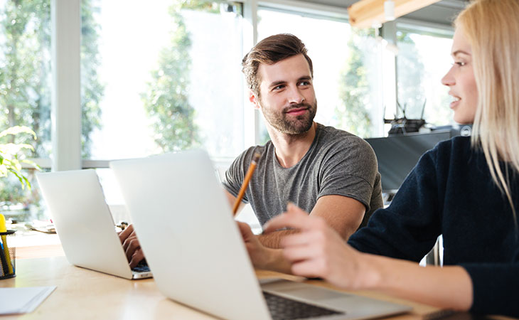 man-woman-talking-laptops