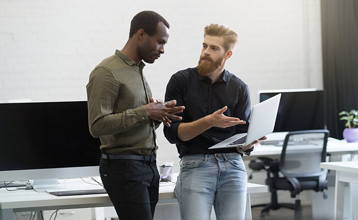 men-talking-potinting-laptop