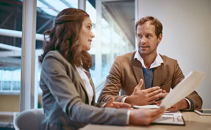 two-people-negotiating-papers-office