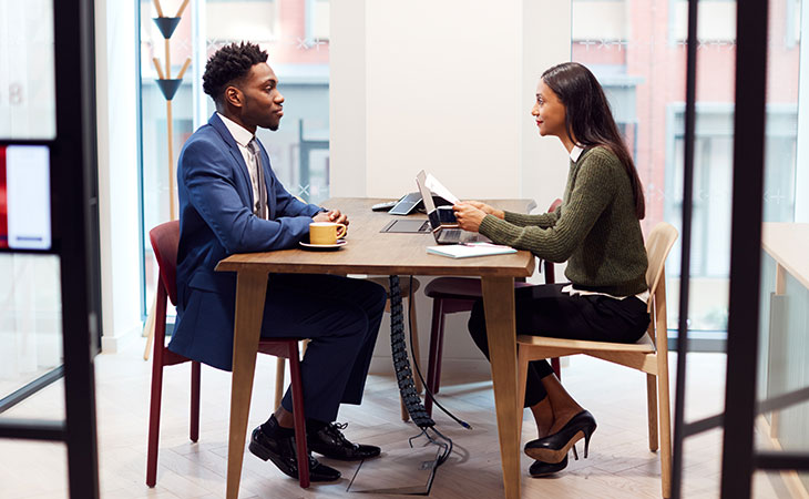 two-people-talking-table