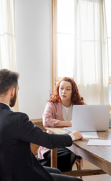 woman-looking-man-table-laptop