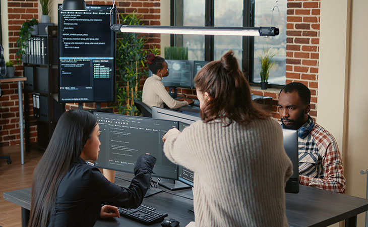 women-talking-office-screen-coding