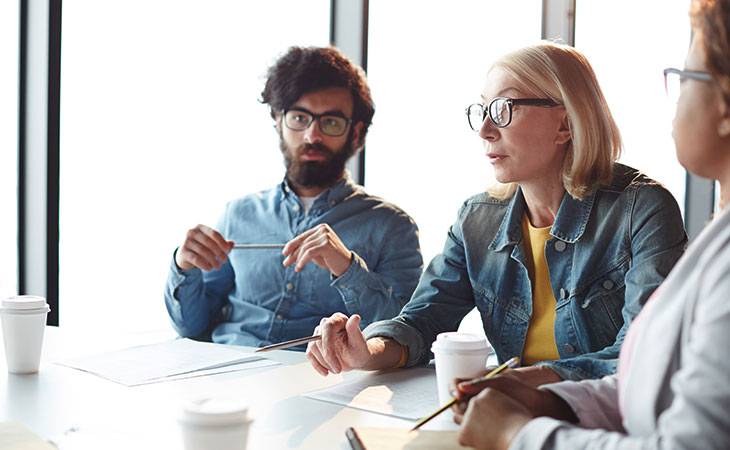 100+ Interview Questions For Product Managers + Answers Evinex Corporation | Staffing Agency workers-talking-meeting-table