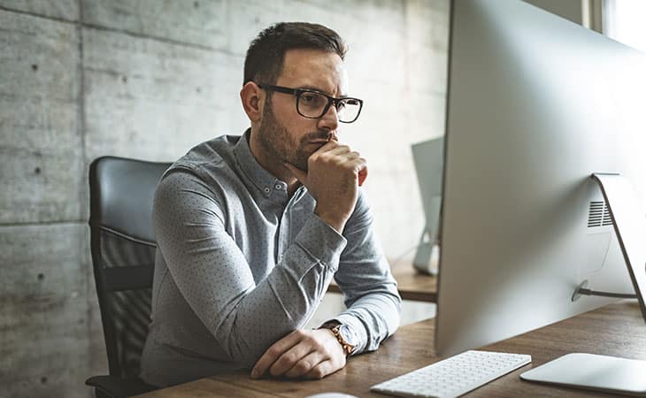 man-thinking-hand-chin-computer