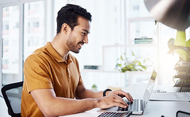 smiling-man-typing-laptop