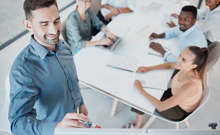 100+ Program Manager Interview Questions To Find Top Talent Evinex Corporation | Staffing Agency smiling-man-writes-board-meeting