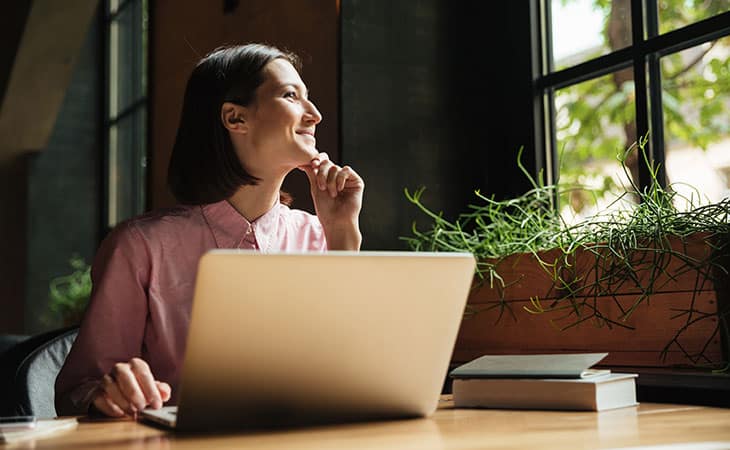 smiling-woman-laptop-smiling-sunlight