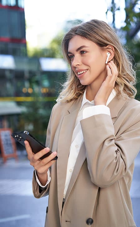 smiling-woman-touches-ear-phone