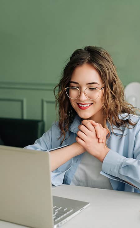 woman-hands-together-looking-laptop