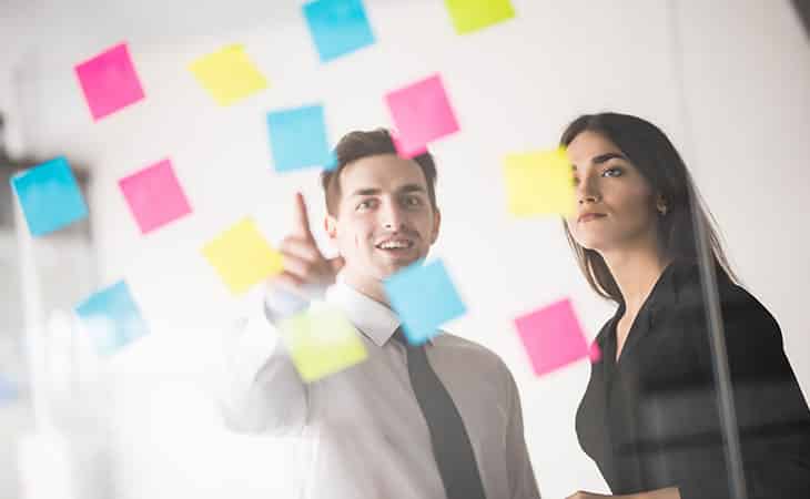 100+ Interview Questions To Identify Top Product Owners Evinex Corporation | Staffing Agency guy-pointing-post-its-woman
