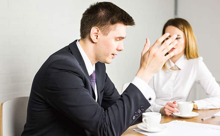 man explaining something to a woman in an office