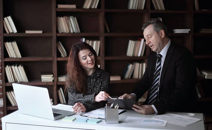 woman and a man working in an office using papers